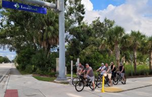 six men on bikes riding an outside trail
