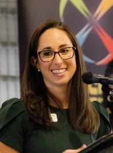 woman with glasses smiles